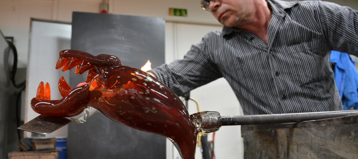 Lasinpuhaltaja Johannes Rantasalo työssään muotoilemassa lasista hirviöhahmoa.